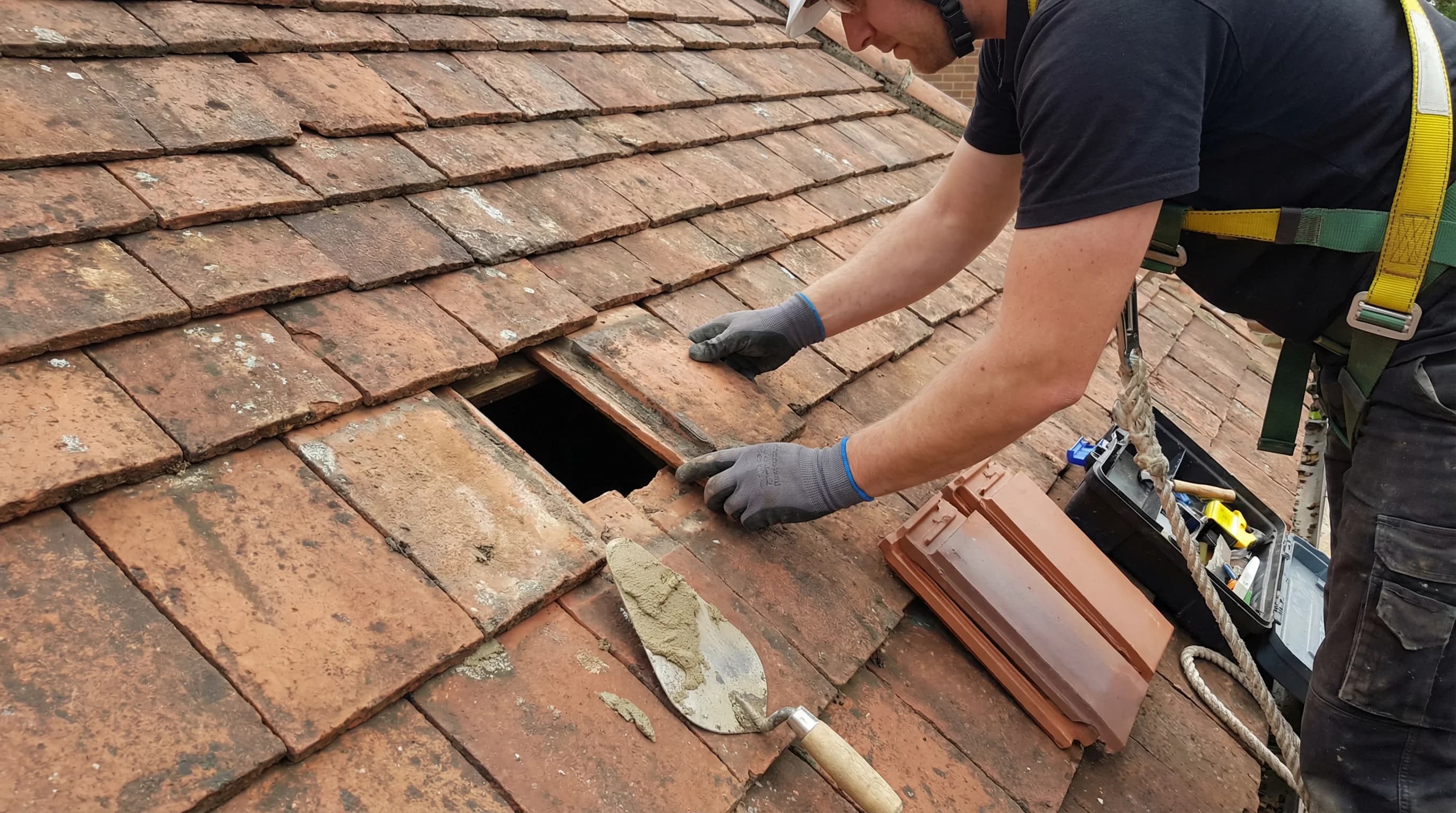 Roofer fixing a tiled roof in Kent